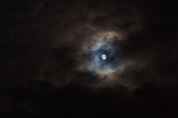 Moon on black cloudy sky, background