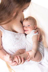 Mom feeds the baby breast, light background