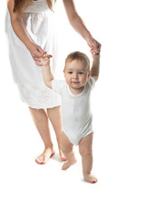 baby walking holding hands mother, white background