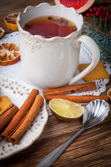 Winter hot drink with spices on wooden table.