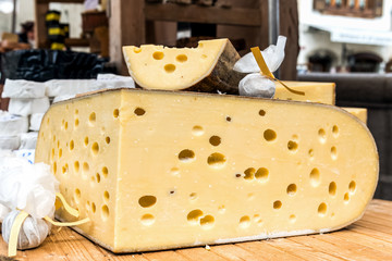 Quarter of Emmental cheese head on the market place.