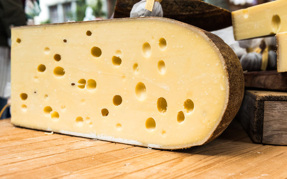 Quarter of Emmental cheese head on the market place. Close-up