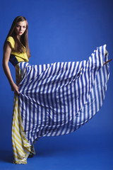 beautiful woman in long yellow blue dress posing dynamic in the