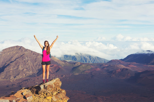 Young Woman with Backpack on Mountain Peak with Open Arms