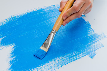 Painter painting with blue acrylic paint