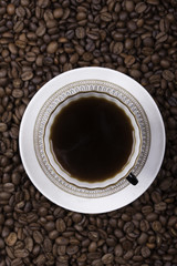 cup of coffee against beans background closeup