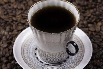 cup of coffee against beans background closeup