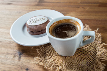 New Year's sweet with coffee on brown wooden background. New Year 2016 in shape of sweets. Design element for, New year's day, Christmas, sweet-stuff, winter holiday, new year's eve, food, etc