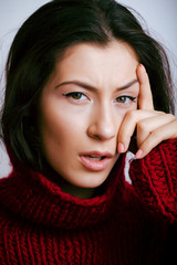 young pretty real woman in red sweater and scarf all over her face smiling at home, winter positive