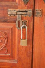 padlock rusty brass brown knocker in a closed wood door