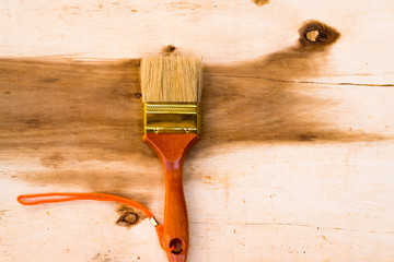 Brand old paint brush on wood background.