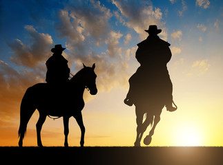 Fototapeta na wymiar Silhouette cowboy with horse in the sunset