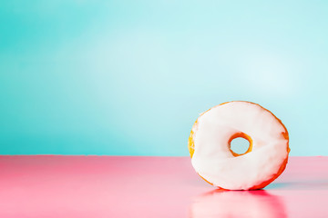White donut on pastel blue and pink background