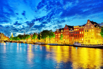 Fototapeta premium Słynna rzeka Amstel i nocny widok na piękne miasto Amsterdam.