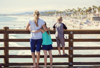 Young family hanging out on an ocean pier on vacation in Southern California