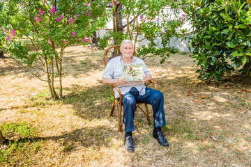 old man showing frame in garden
