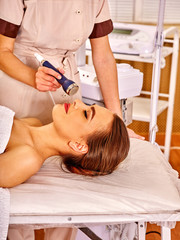Obraz na płótnie Canvas Young woman receiving electric facial massage.