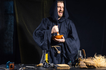 Portrait of a crazy medieval scientist working in his laboratory.