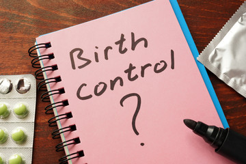 Notebook with the words Birth control  on the table.