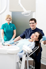 Obraz premium Female patient with dentist and assistant