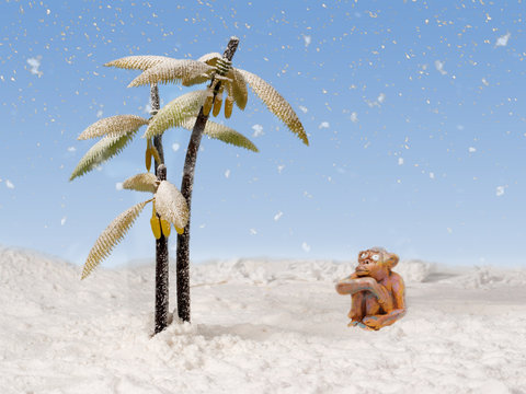 clay monkey looks at the snow falling from the sky near the snow-covered palm trees