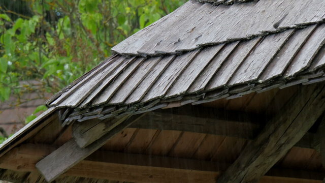Black wooden shingles from the rooftop. The wooden log house in the middle of the forest