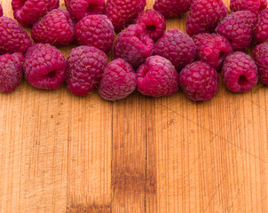 Ripe sweet raspberries on wood table close-up