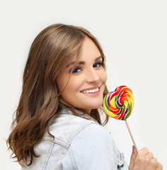 Laughing girl holding big lollipop.Blue background.