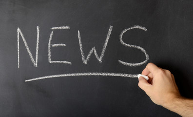 News concept on black blackboard with businessman hand