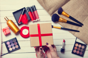 hands are wrapping cosmetics in christmas gifts