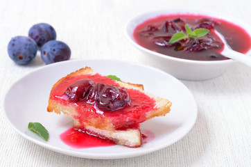 Toasted bread with plum jam on a white plate