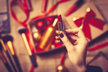 hands are wrapping cosmetics in christmas gifts
