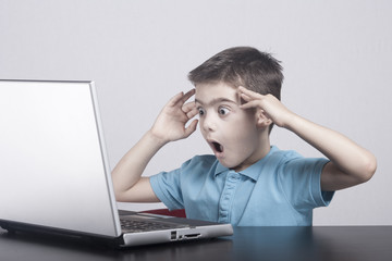Boy reacts while using a laptop