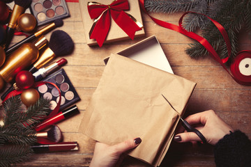 Female hands are wrapping cosmetics