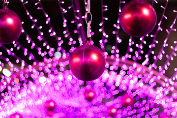 Fototapeta premium Red Christmas balls with blurred lights at the background.