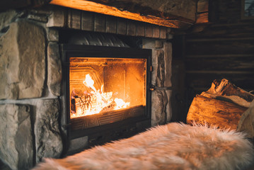 Warm cozy fireplace with real wood burning in it. Cozy winter concept. Christmas and travel background with space for your text