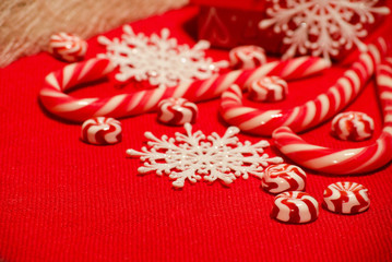 Christmas composition with red-white candies and snowflakes on a