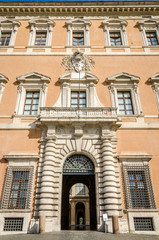 Fototapeta na wymiar Building Lateranense Palace with a gate for the entry of vehicles and columns, as well as architectural ornaments windows in Rome, capital of Italy