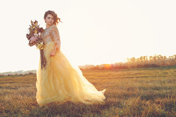 Cute lady walking through the field. Sunset background