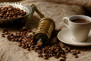 Roasted coffee beans and traditional coffee grinder with nice sack backgrounds