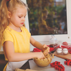 Happy little child baking Christmas cookies at home