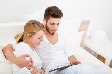 Young couple with a Tablet PC in Bed