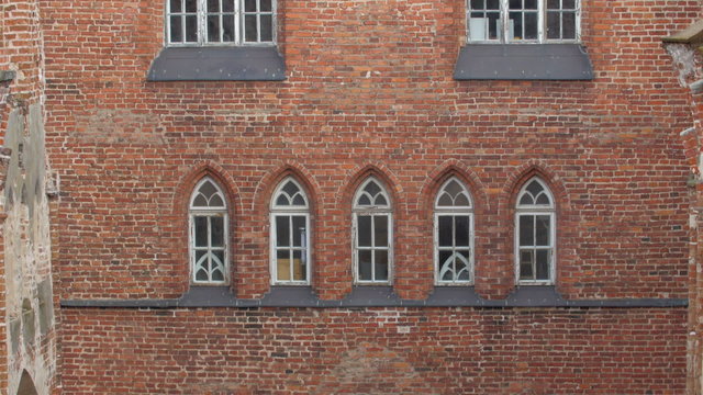 The red bricked wall old building. It is an old church from the medieval time with ruins seen on the wall