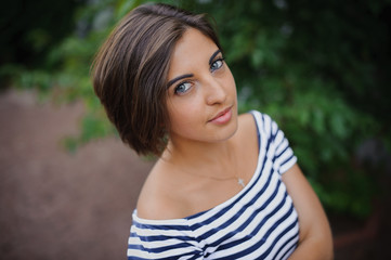 Closeup portrait of a bobbed haired young woman in park