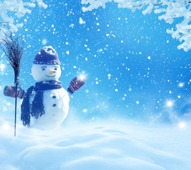 Happy snowman standing in winter christmas landscape