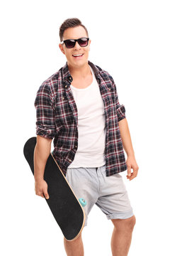 Young confident man holding a skateboard