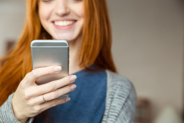 Fototapeta premium Redhead woman using smartphone