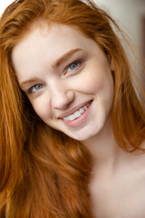 Naklejka premium Closeup portrait of charming positive lady with long red hair