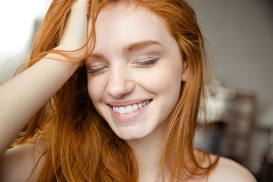 Smiling redhead woman with closed eyes