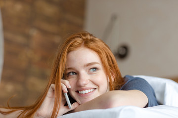 Woman talking on the phone in bed